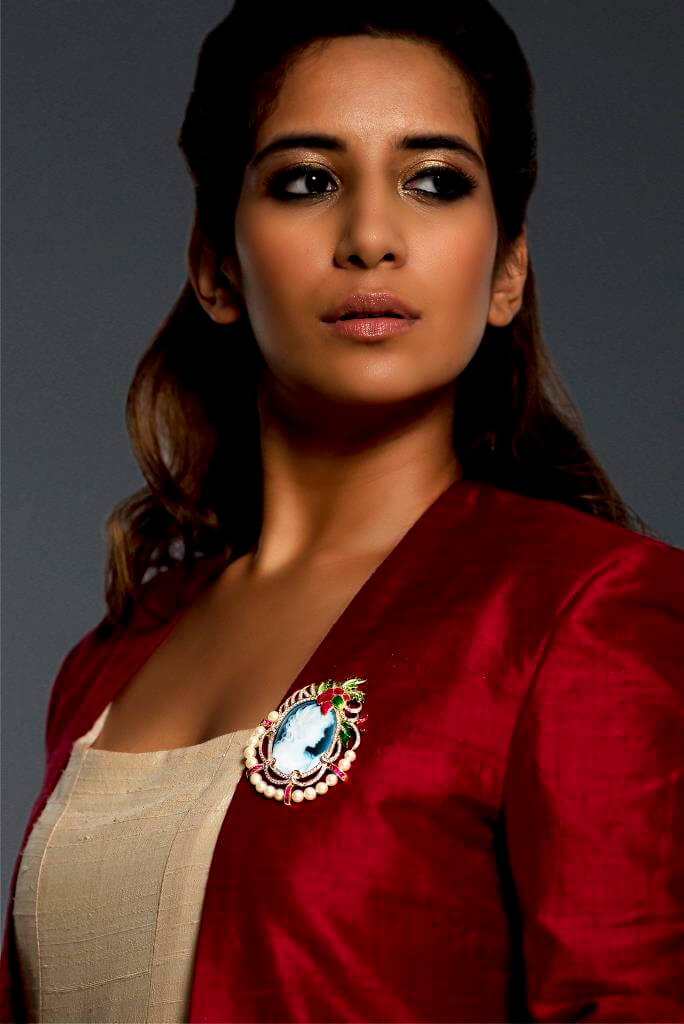 Model wearing a beautiful Brooch cum pendant in 18K gold featuring princess cameo of 40x30mm with diamonds, calibre cut and marquise shapes rubies and pearls, accentuated by french enamel.